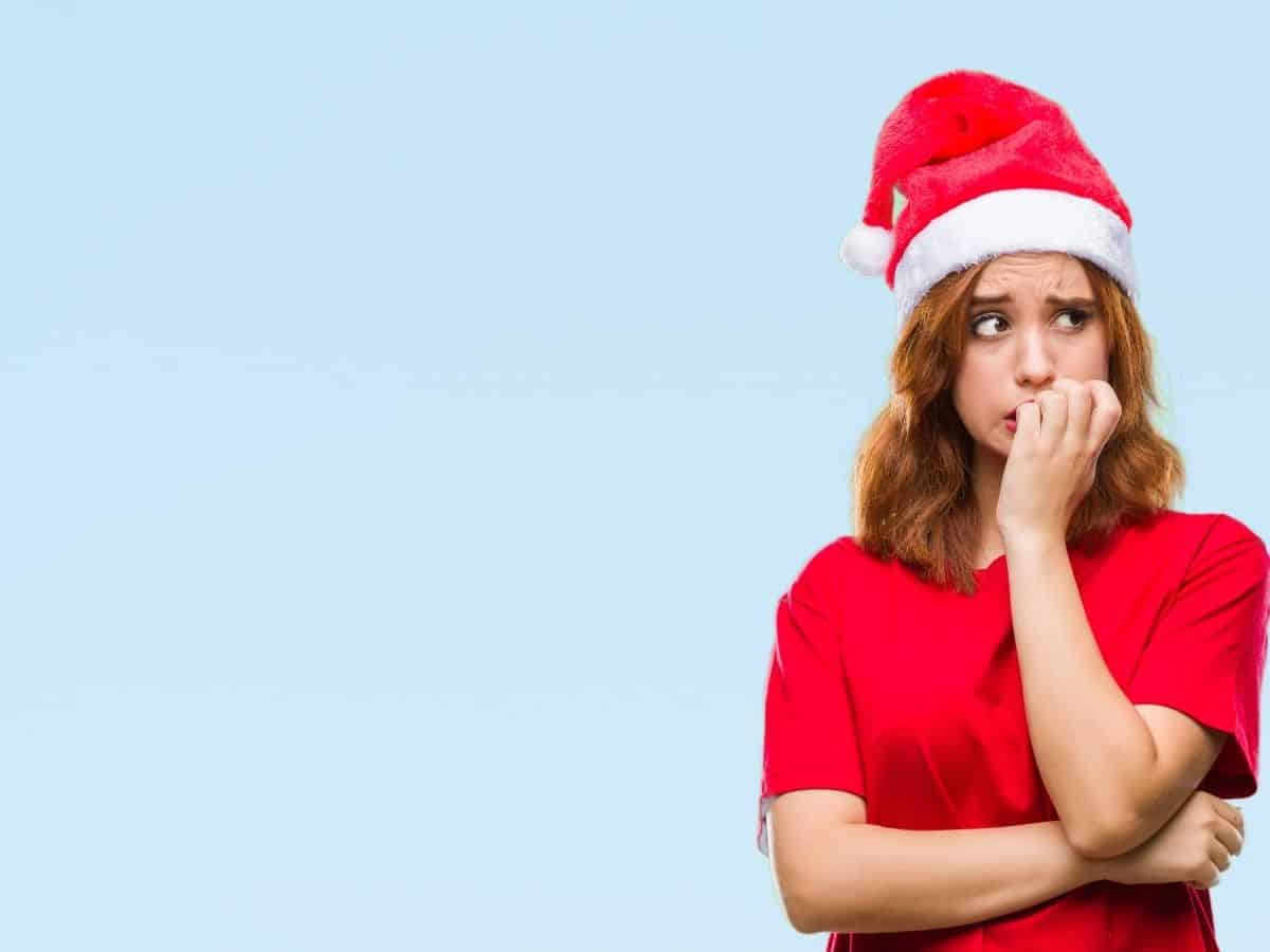 a woman wearing a santa hat who looks nervous