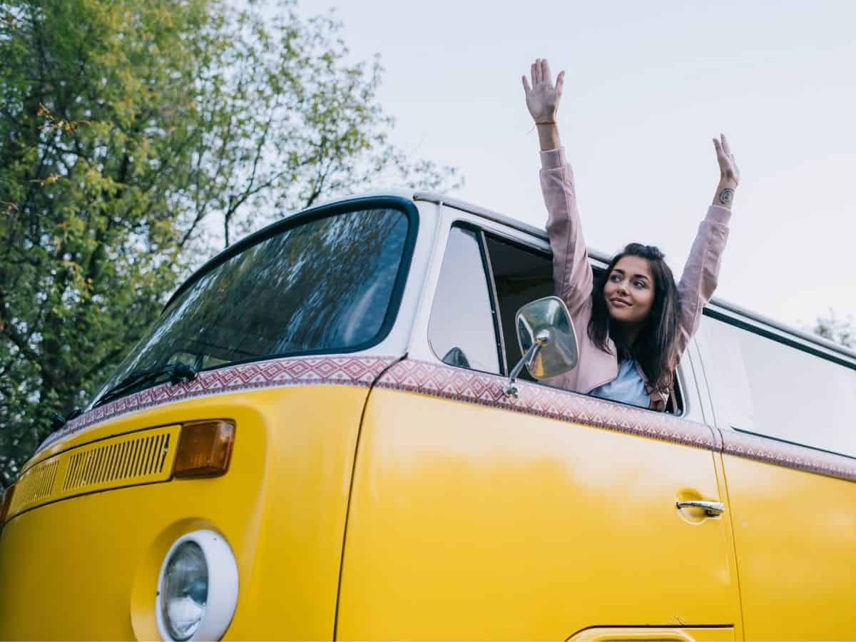 a woman with looking out the window of a volkswagen travel van