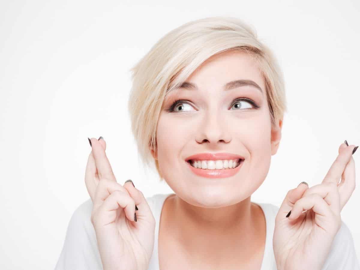 a woman crossing her fingers who looks positive