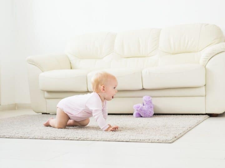 a young baby crawling at home on the floor