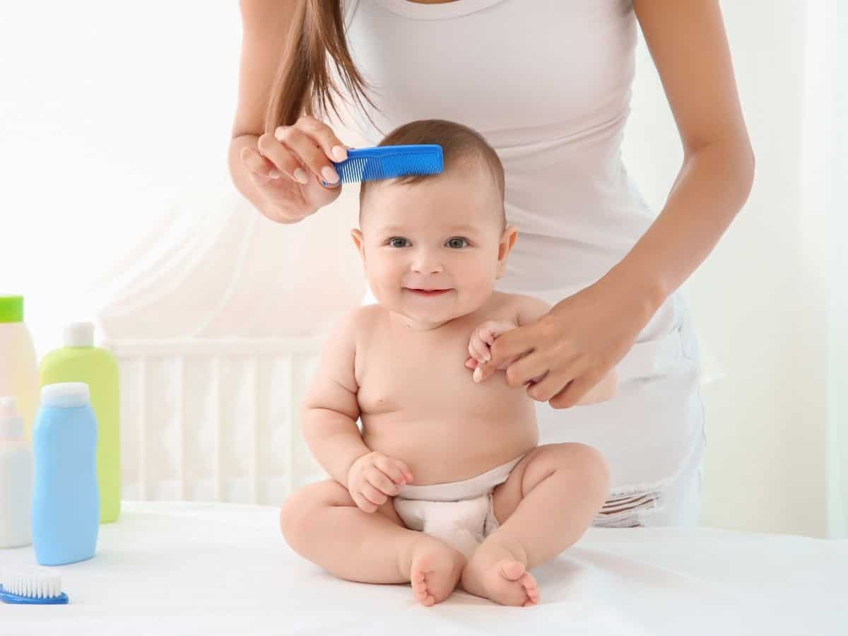 a mom combing her baby's hair