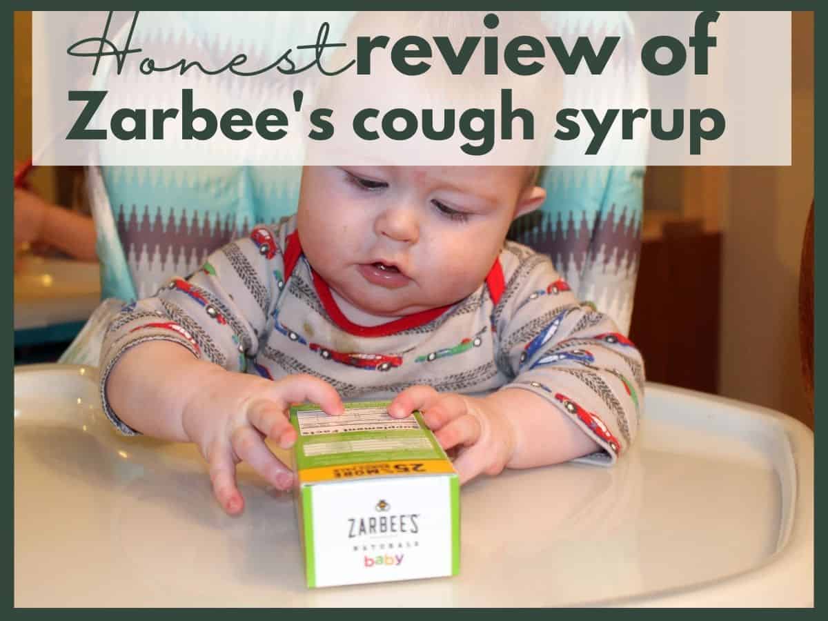 a baby in a high chair holding an empty box of Zarbee's with text overlay that reads honest review of zarbee's cough syrup