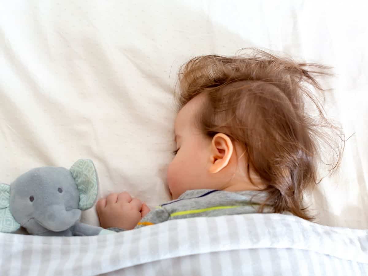 a young baby napping on her bed