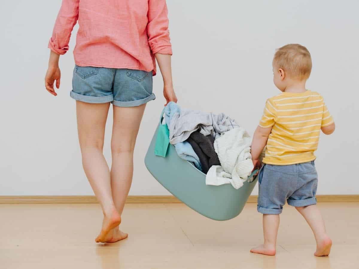 a mom with her son carrying a laundry basket