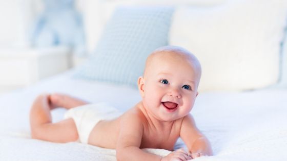 a happy looking baby doing tummy time