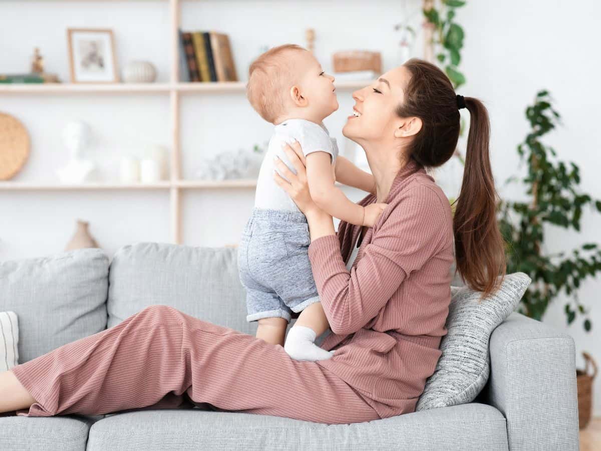 a mom holding her son on the couch at home