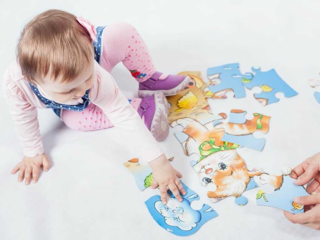 a toddler putting a puzzle together