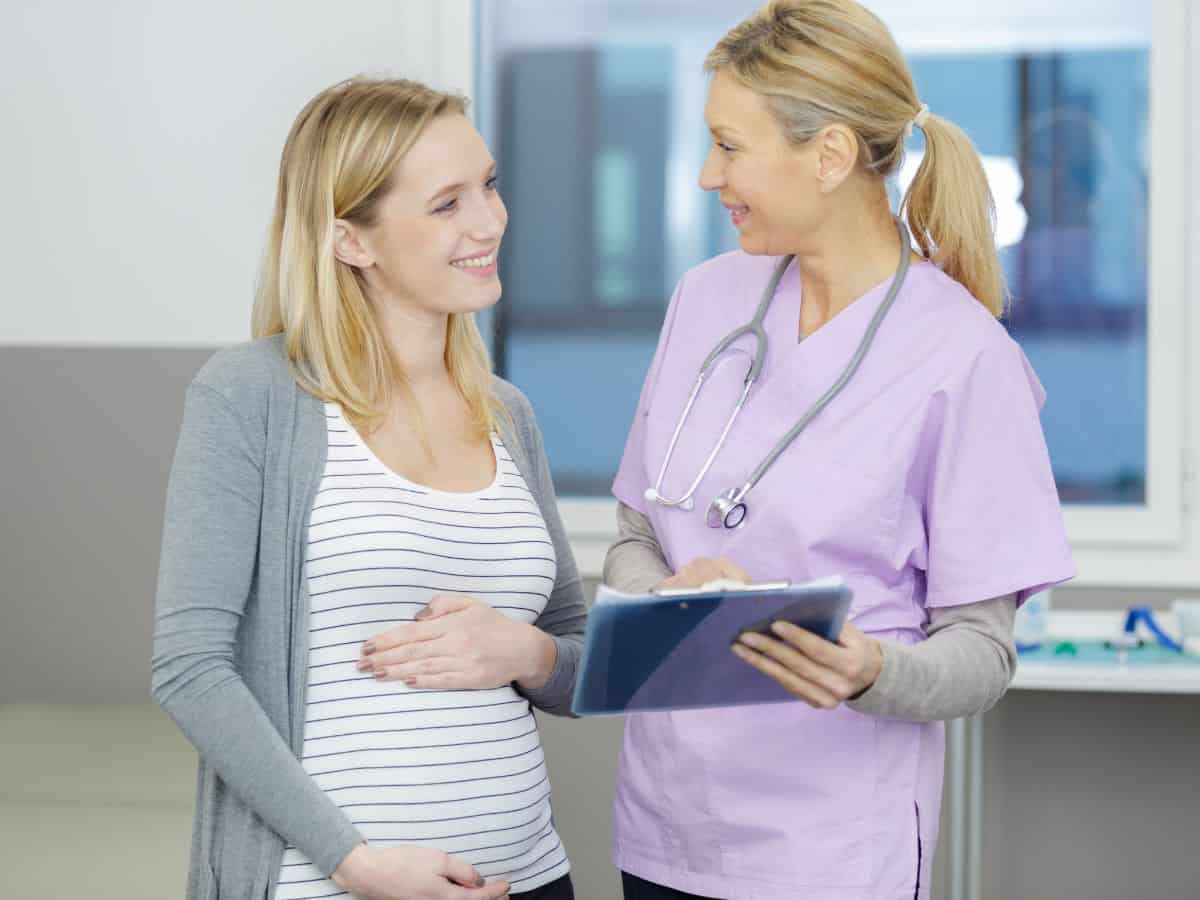 a young pregnant woman talking to a doctor