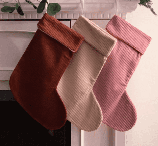 three corduroy stockings hanging on a mantle