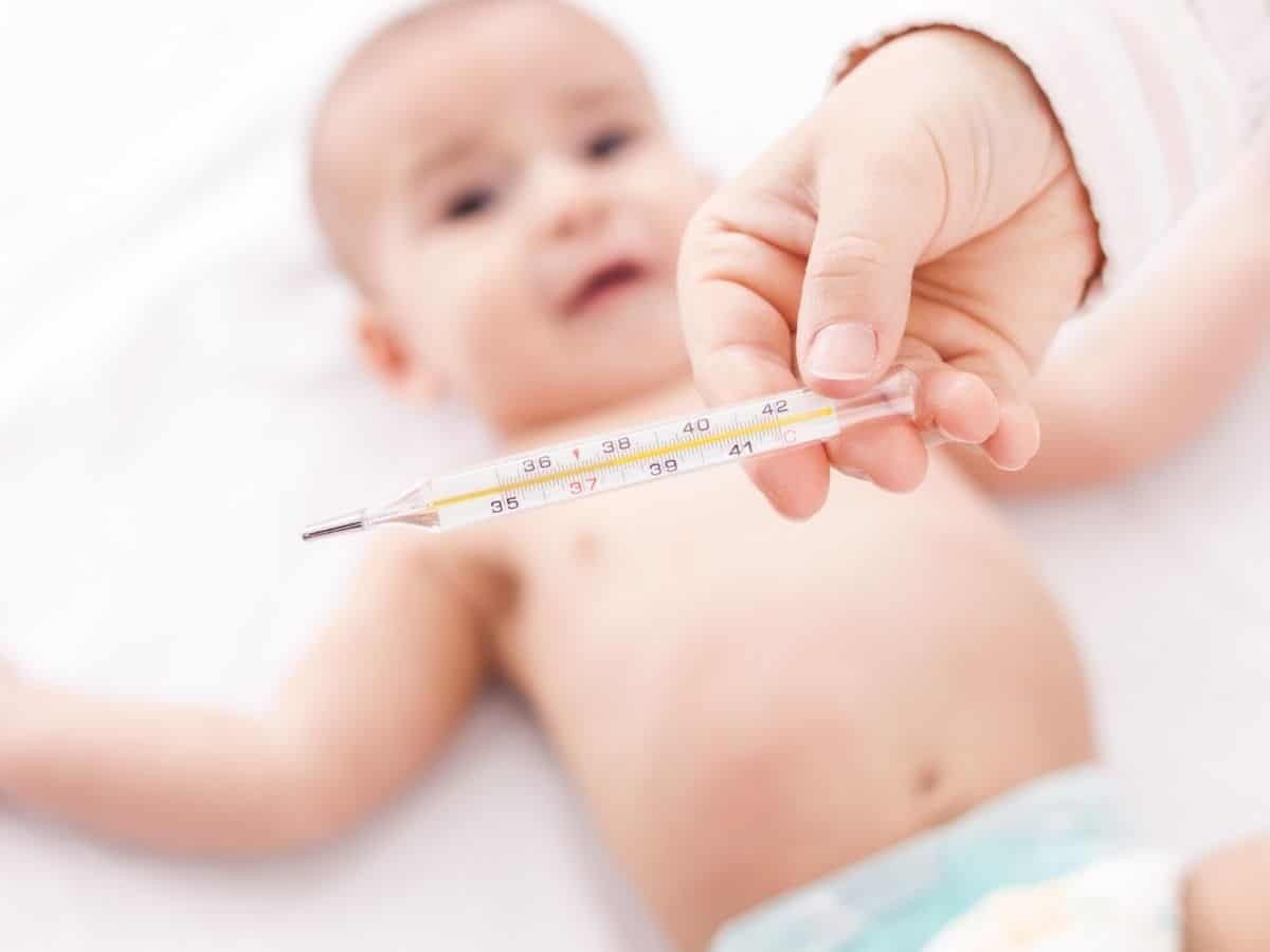 a mom checking her baby's temperature with a thermometer