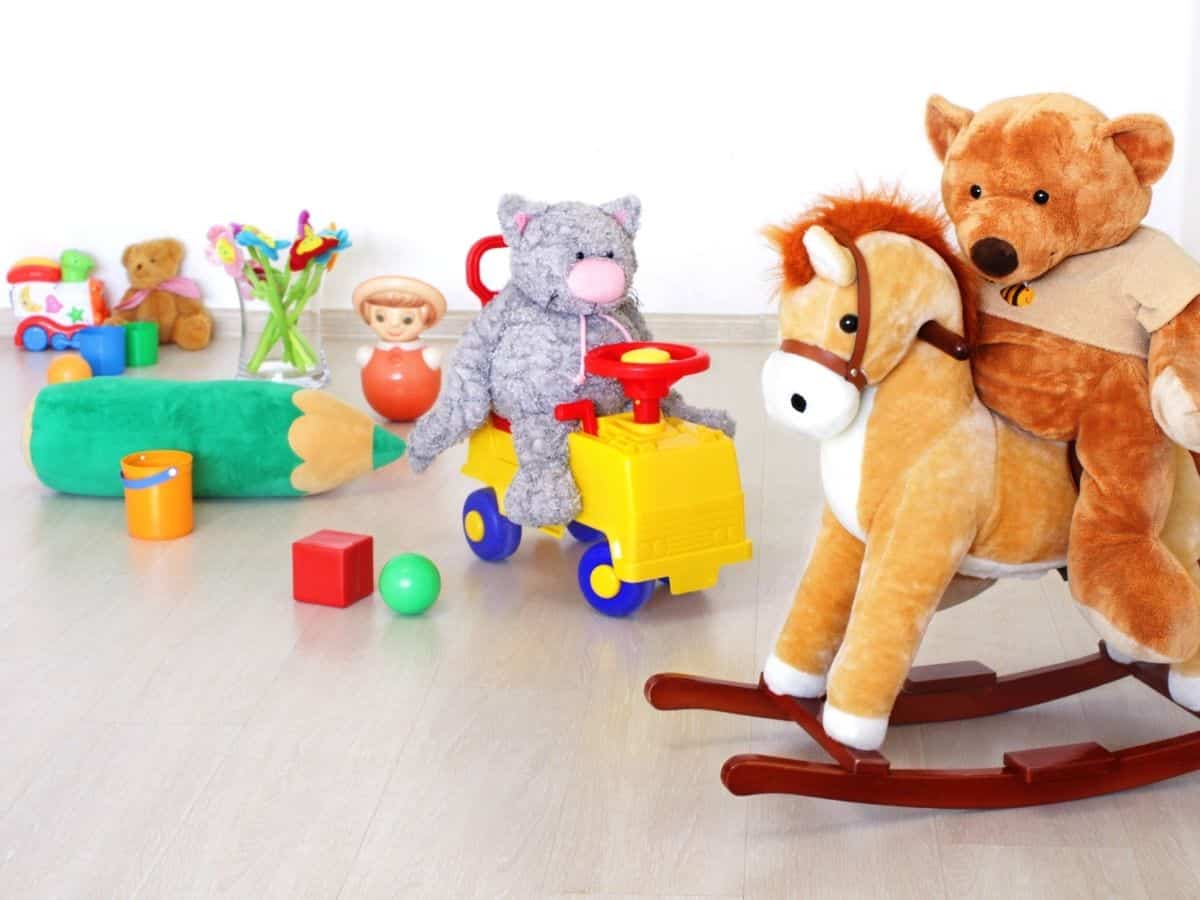 a bunch of toys teddy bears and a rocking horse.
