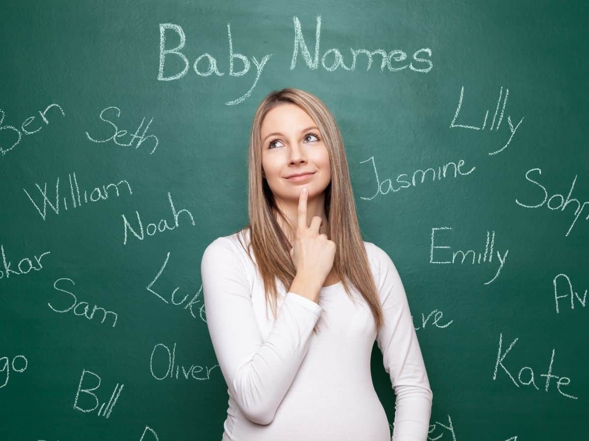 a woman with a chalkboard in the background with different baby names written on it