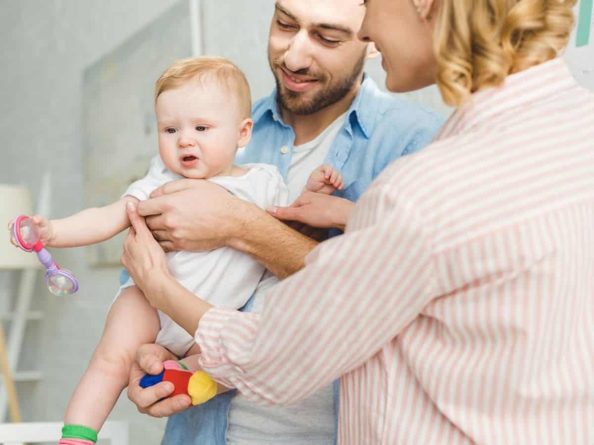 a mom handing baby to her dad