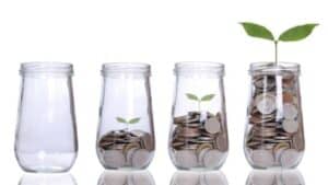 glass jars with money that is growing