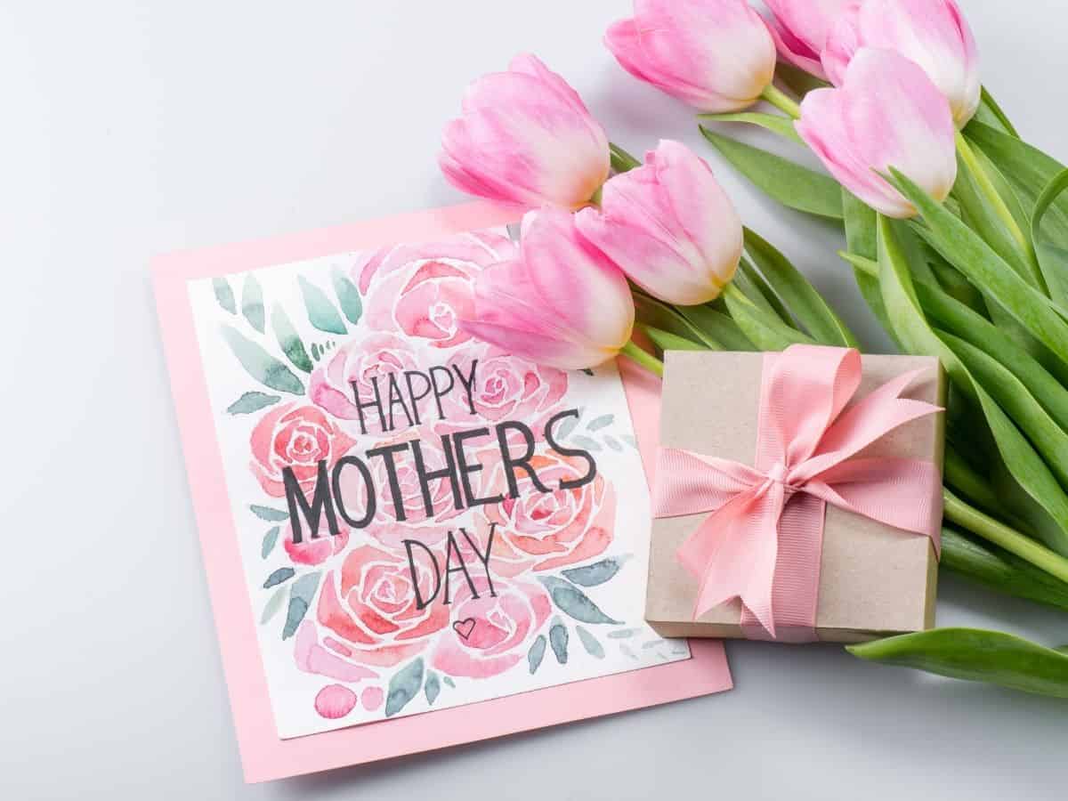 a mother's day card next to a gift with some fresh pink tulips