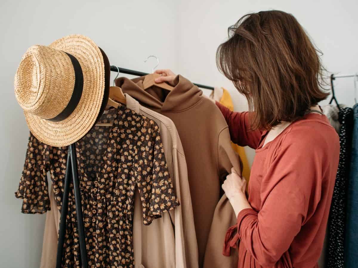 a woman organizing her closet starting with her dresses