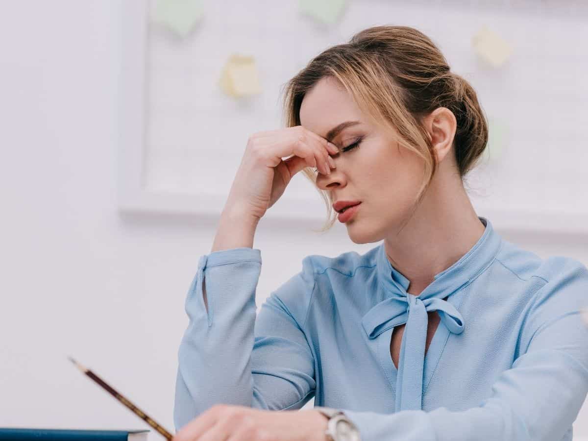 an exhausted woman rubbing her eyes