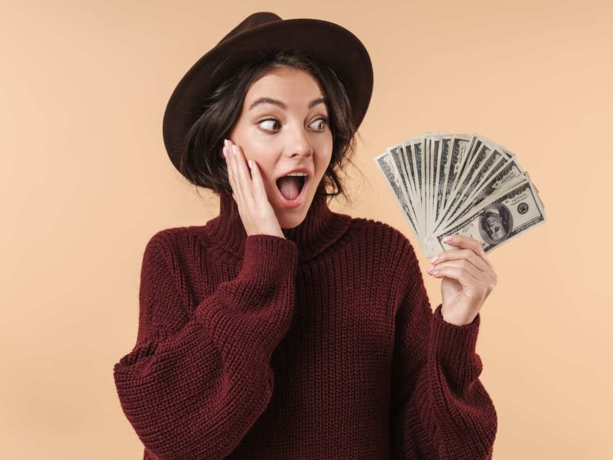 a young woman holding a bunch of cash