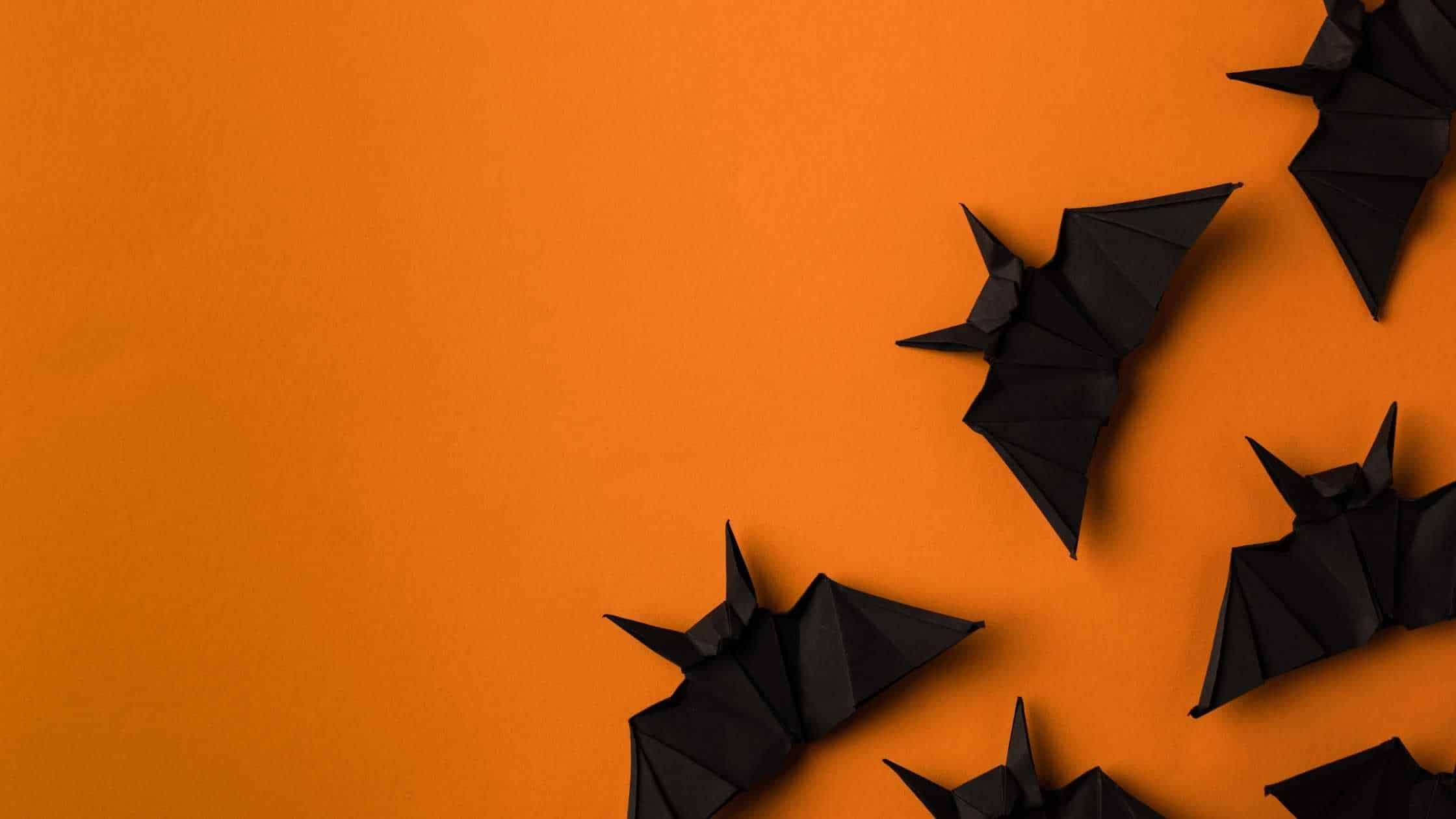 black paper bats on an orange background