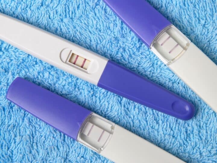 three positive pregnancy tests on a blue background