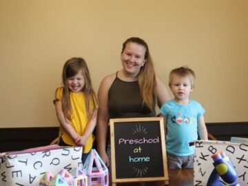 a mom and her two kids with a sign that says preschool at home
