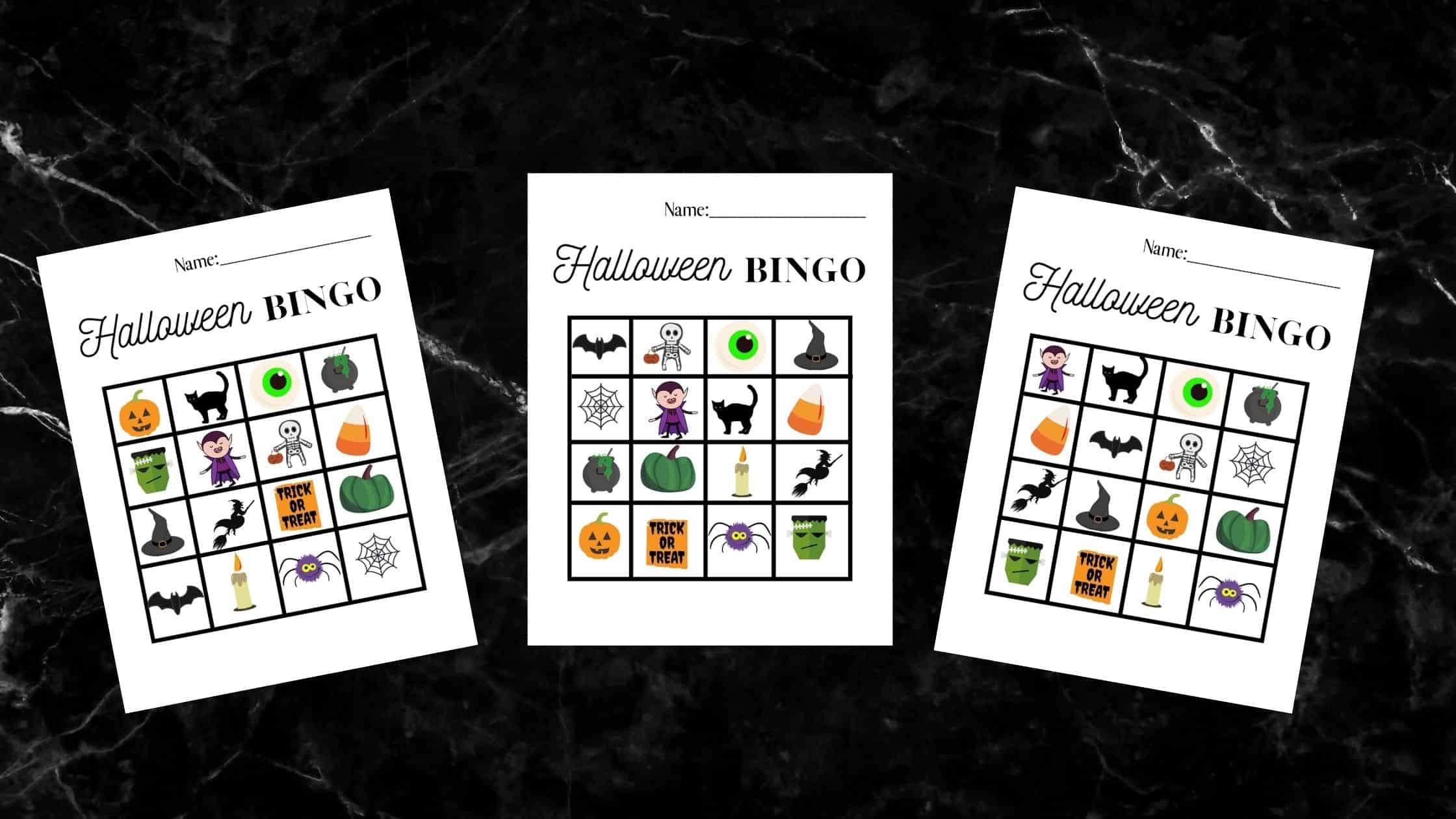 three halloween bingo card worksheets on a black marble counter top