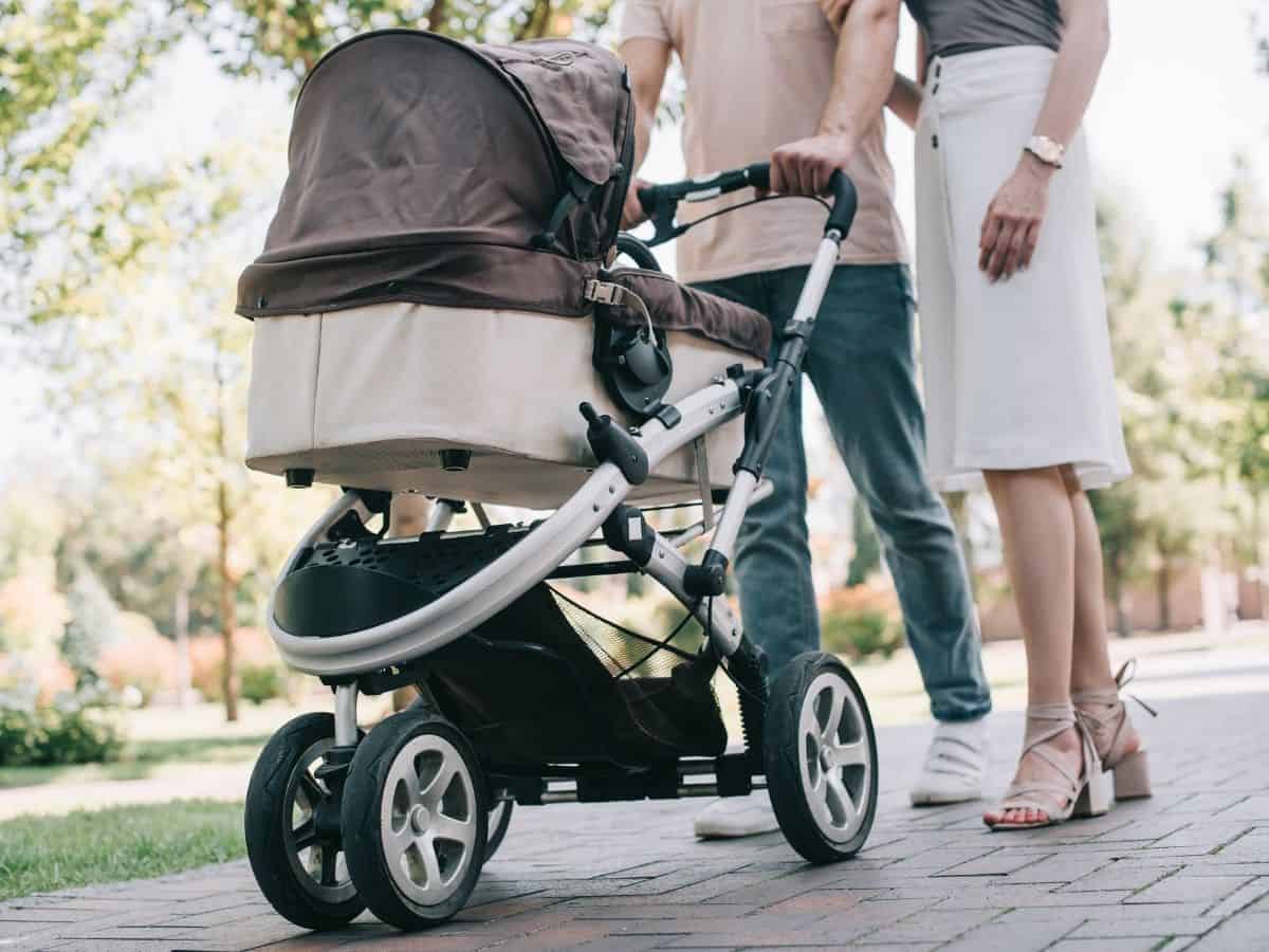 a couple pushing a baby stroller in the park