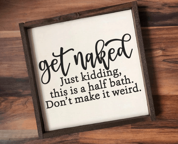 a funny decorative sign that says "get naked just kidding this is a half bath. Don't make it weird."