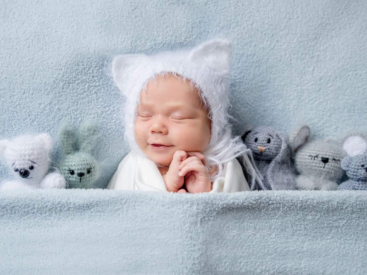 a baby snuggled up by some stuffed animals