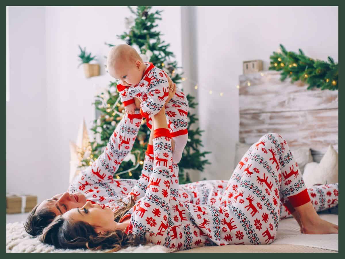 a mom dad and baby wearing matching Christmas pajamas