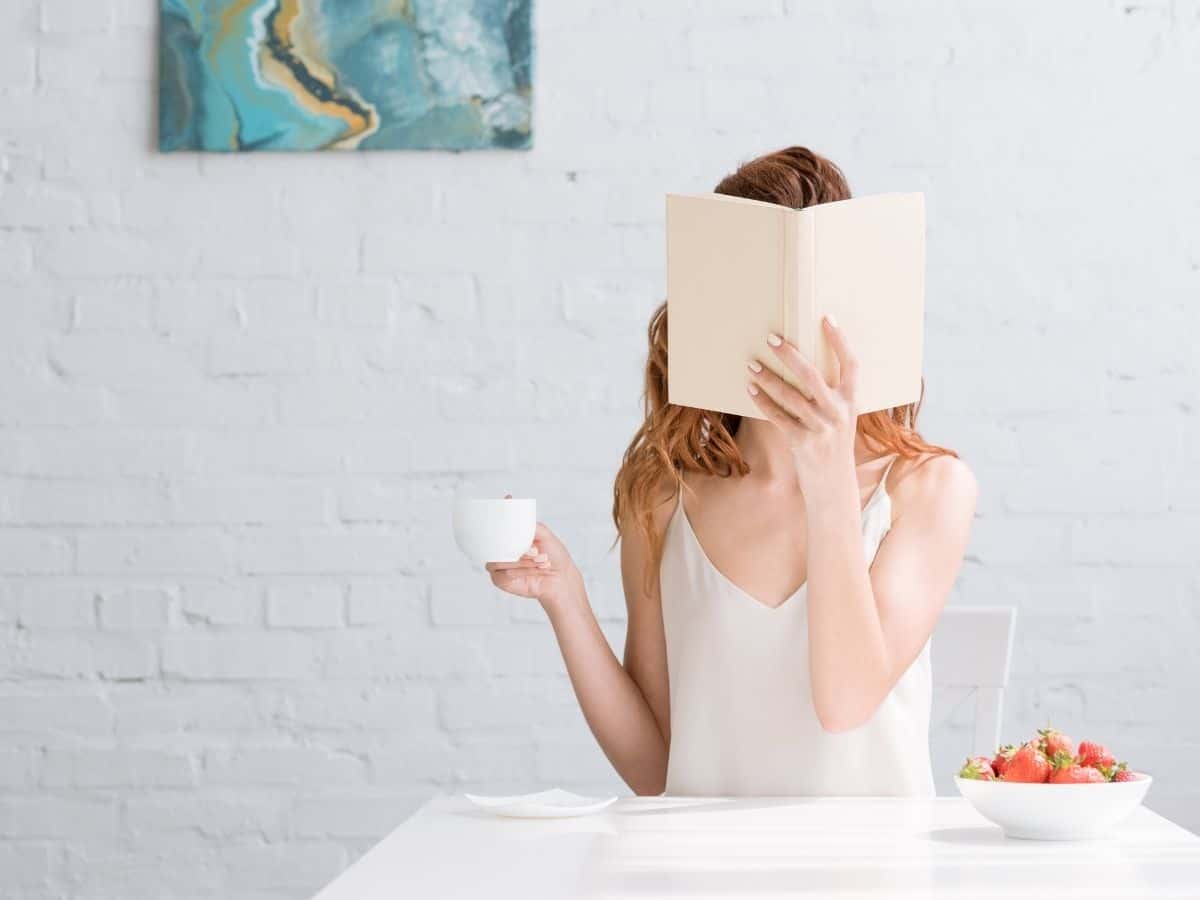 a woman holding a book completely immersed.