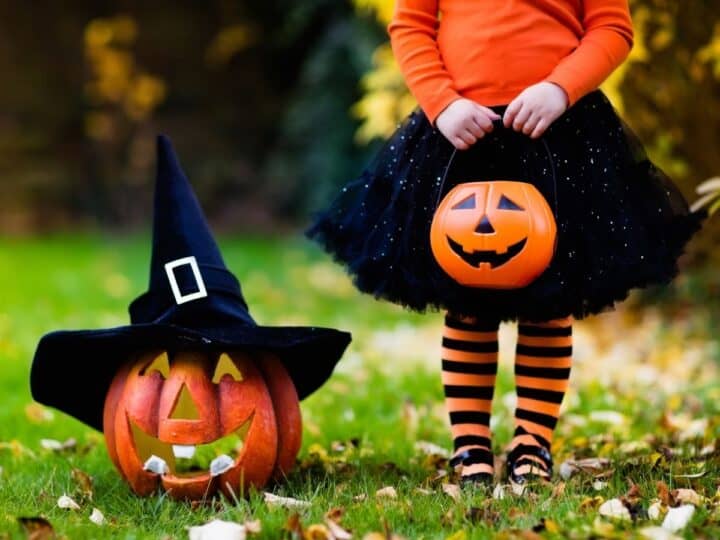 a girl dressed up for halloween in a costume next to a pumpkin