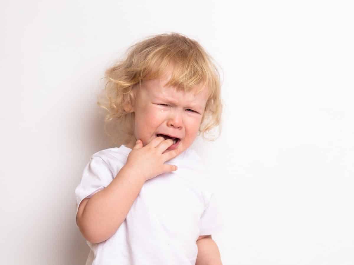 a fussy toddler sucking on their hand