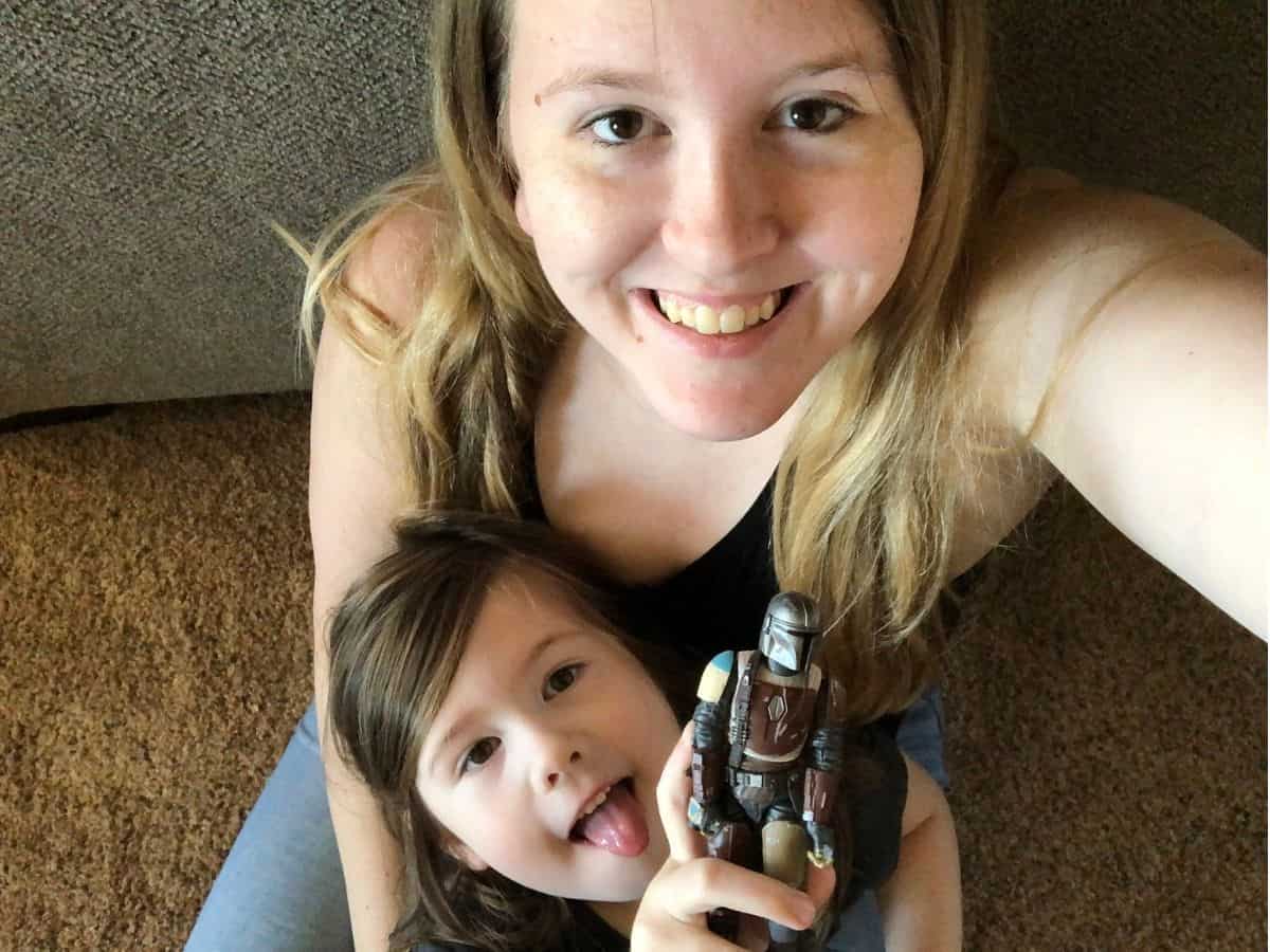 a mom and daughter holding a mandalorian figurine