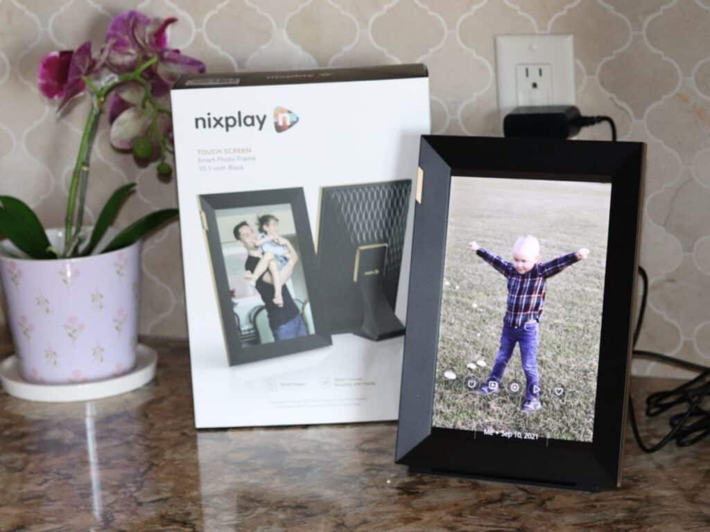 digital photo frame by the nixplay box and an orchid