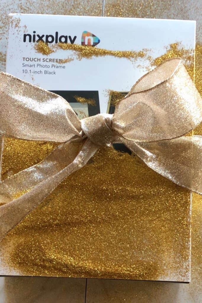 nixplay photo frame in its box and gold glitter on it with a bow