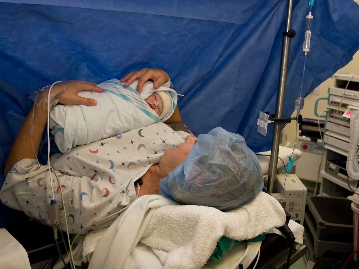 a mom having a gentle c section getting to hold her baby