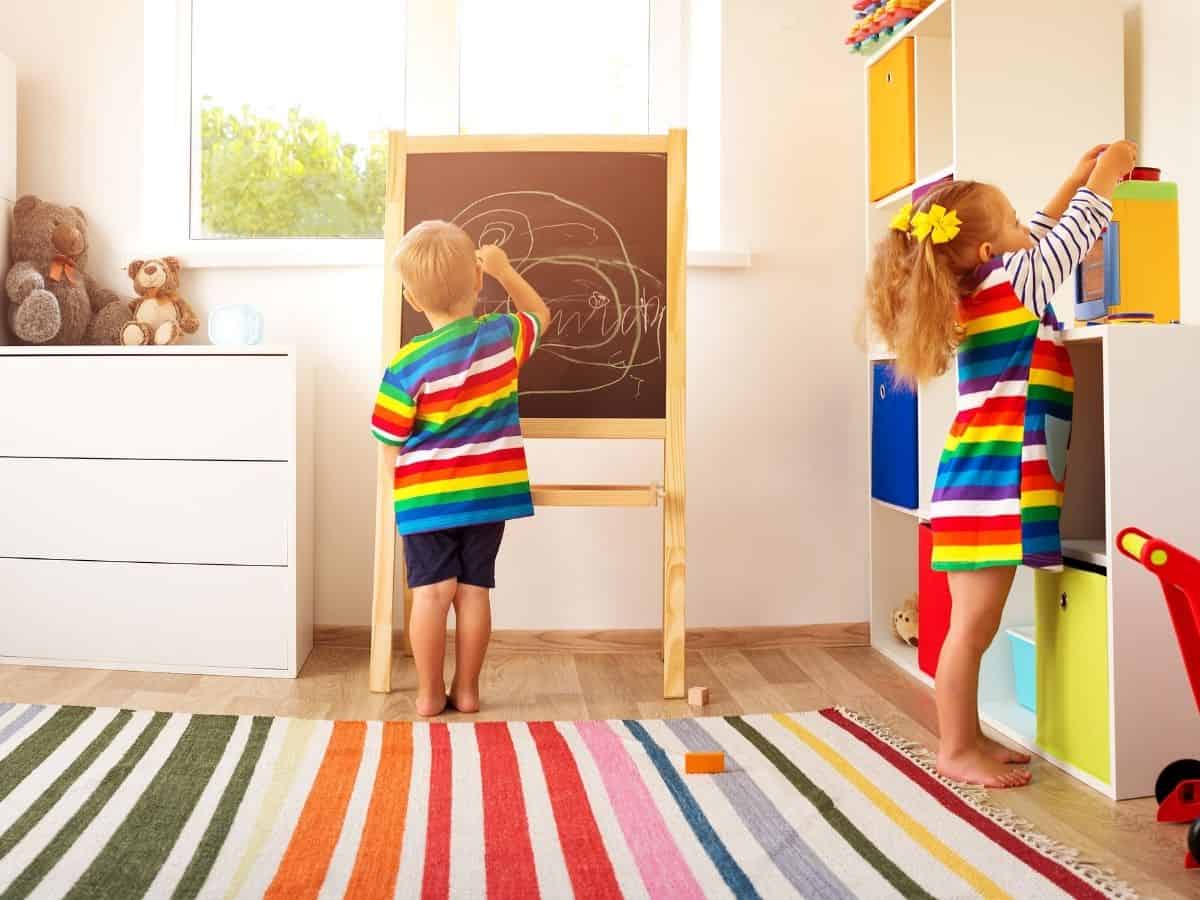 two kids in a room playing with different toys