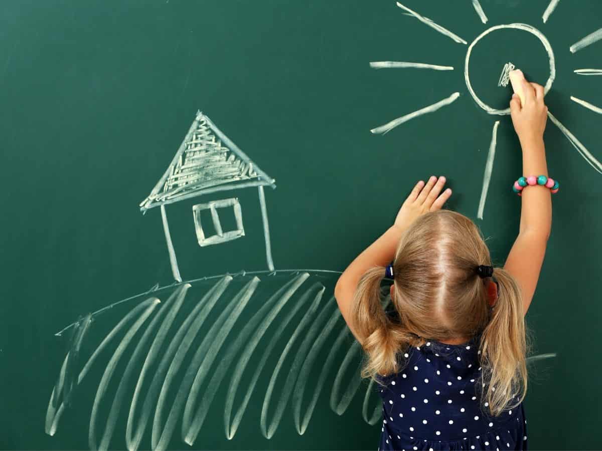 a girl drawing on a chalkboard