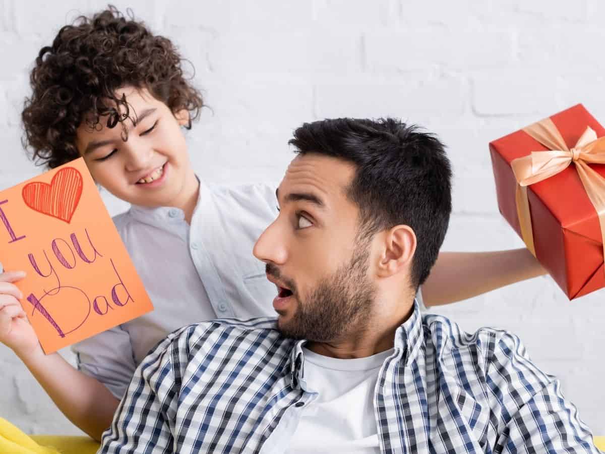 a son giving his dad a fathers day gift and card