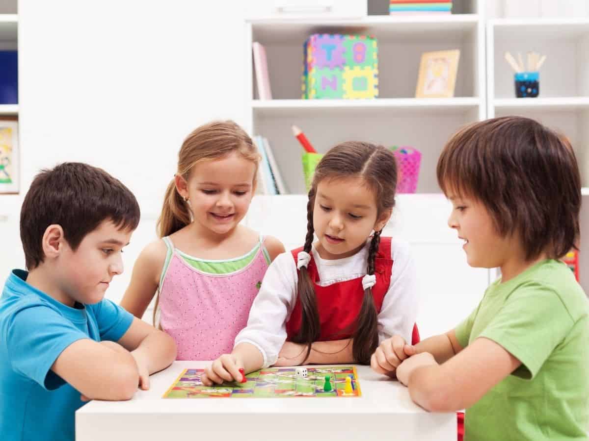 four kids playing with board games