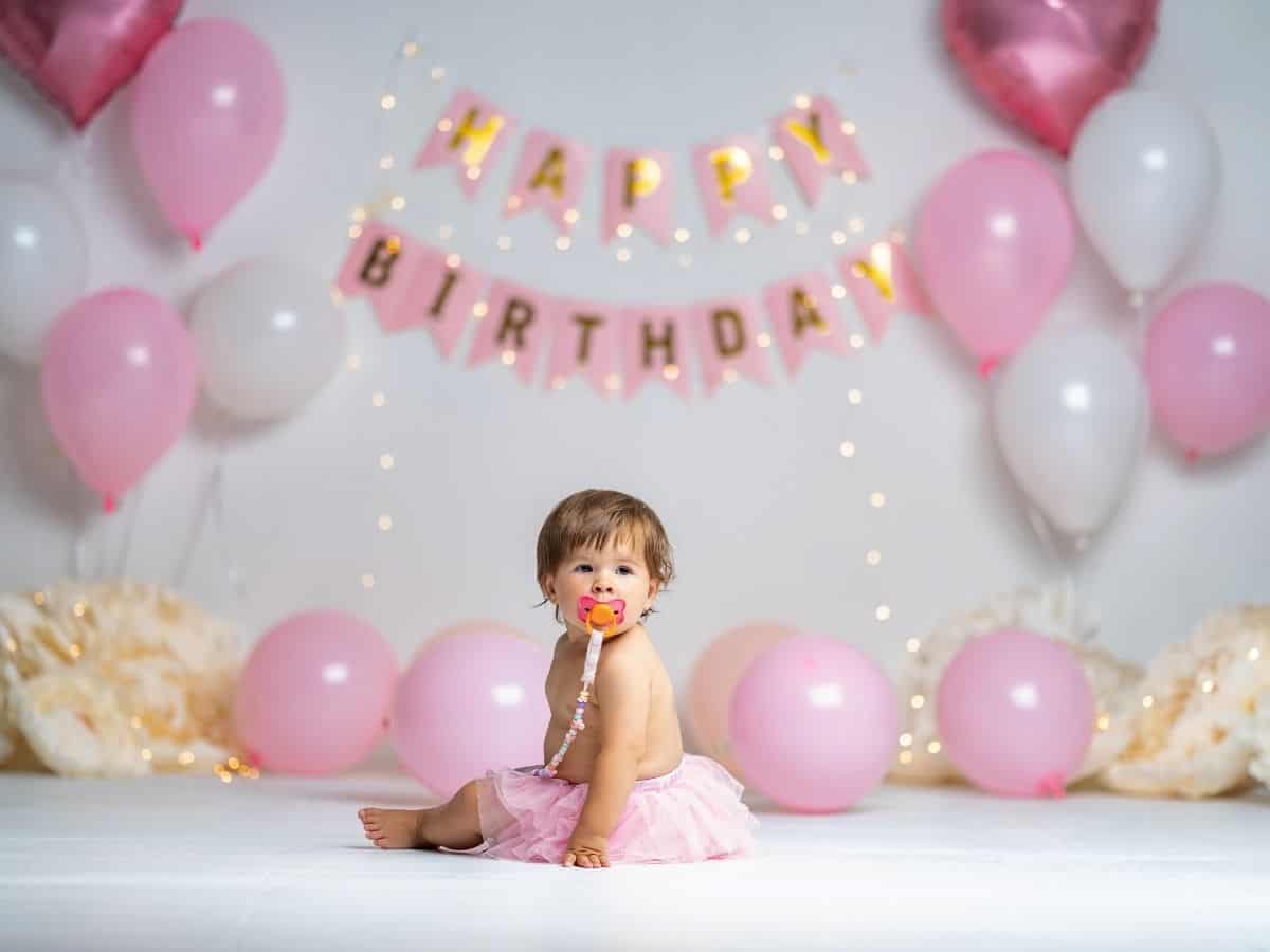 a 1 year old girl with a pacifier at her birthday party