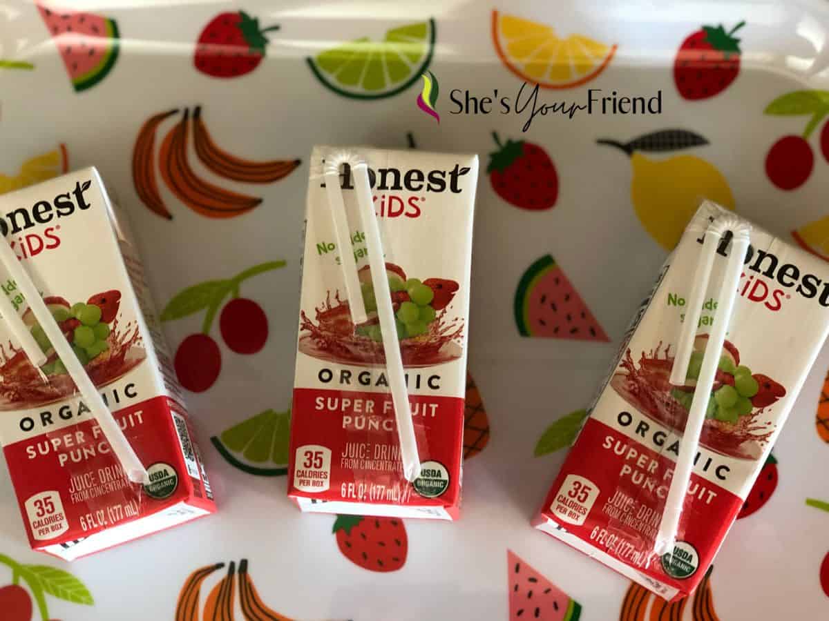 three Honest Kids Juice boxes on a fun fruit plate