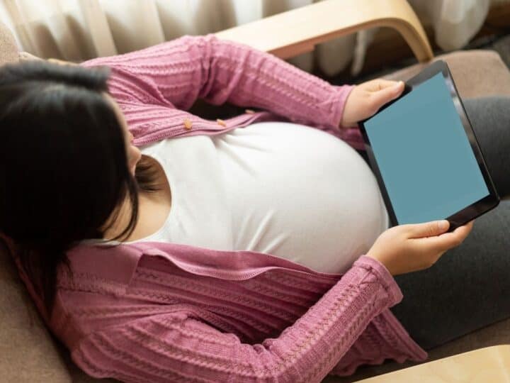 a pregnant woman holding her tablet