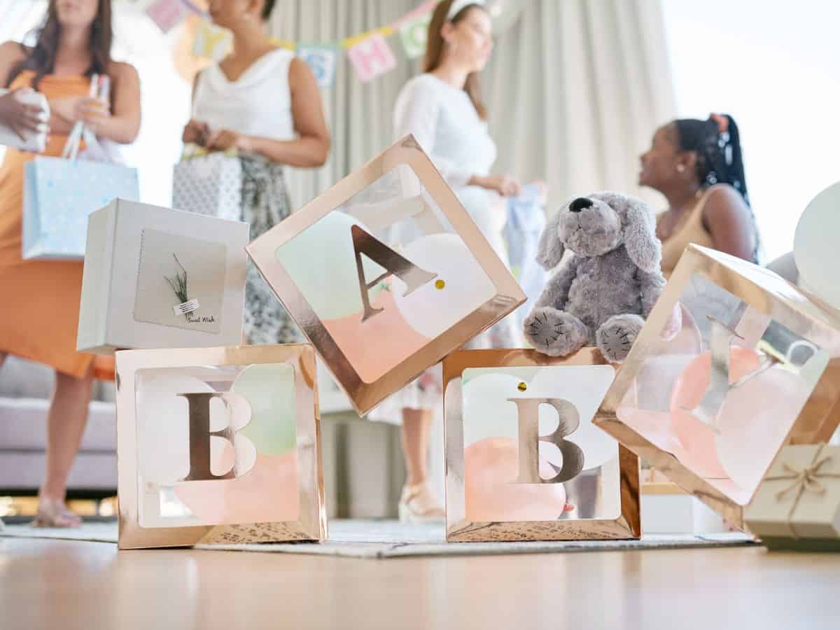 women attending a baby shower with boxes that spell baby
