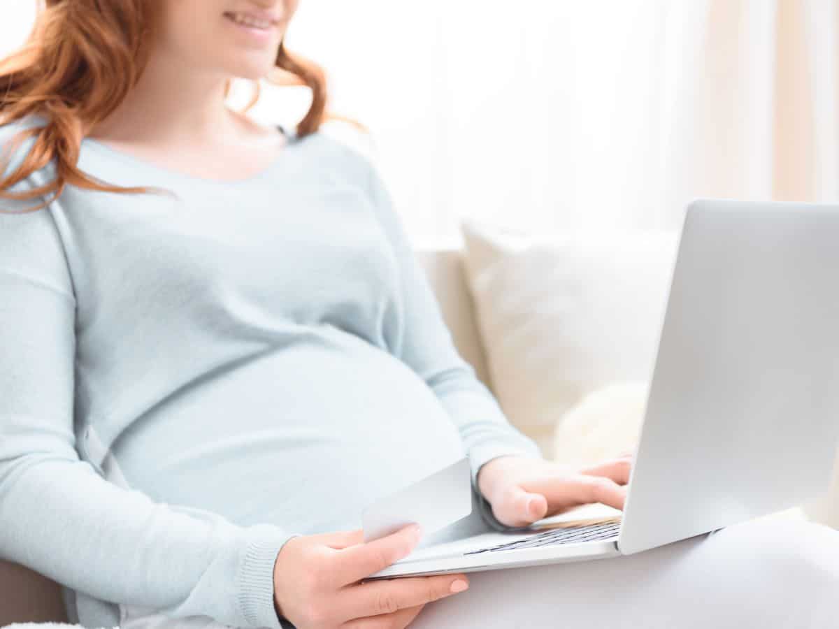 a pregnant woman looking at her laptop