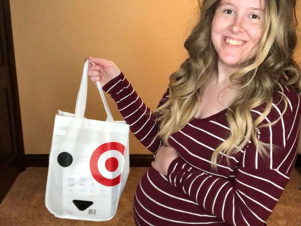 a pregnant woman holding a target baby registry welcome kit
