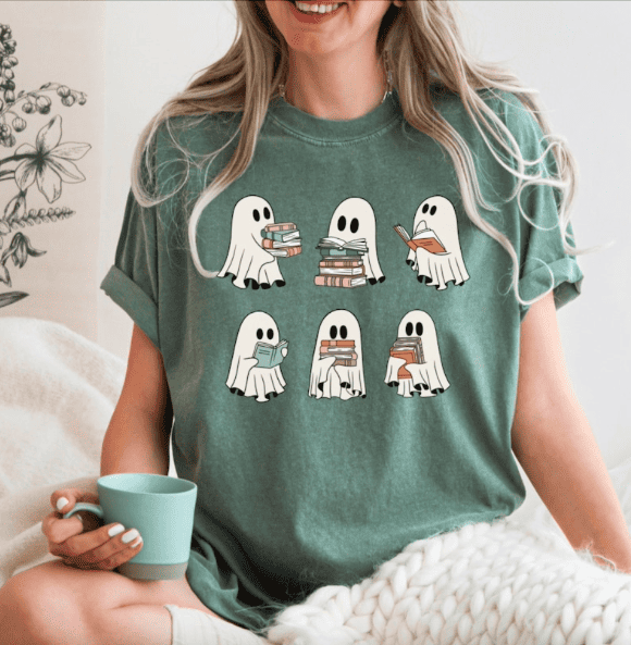 a woman wearing a shirt with ghosts who are reading