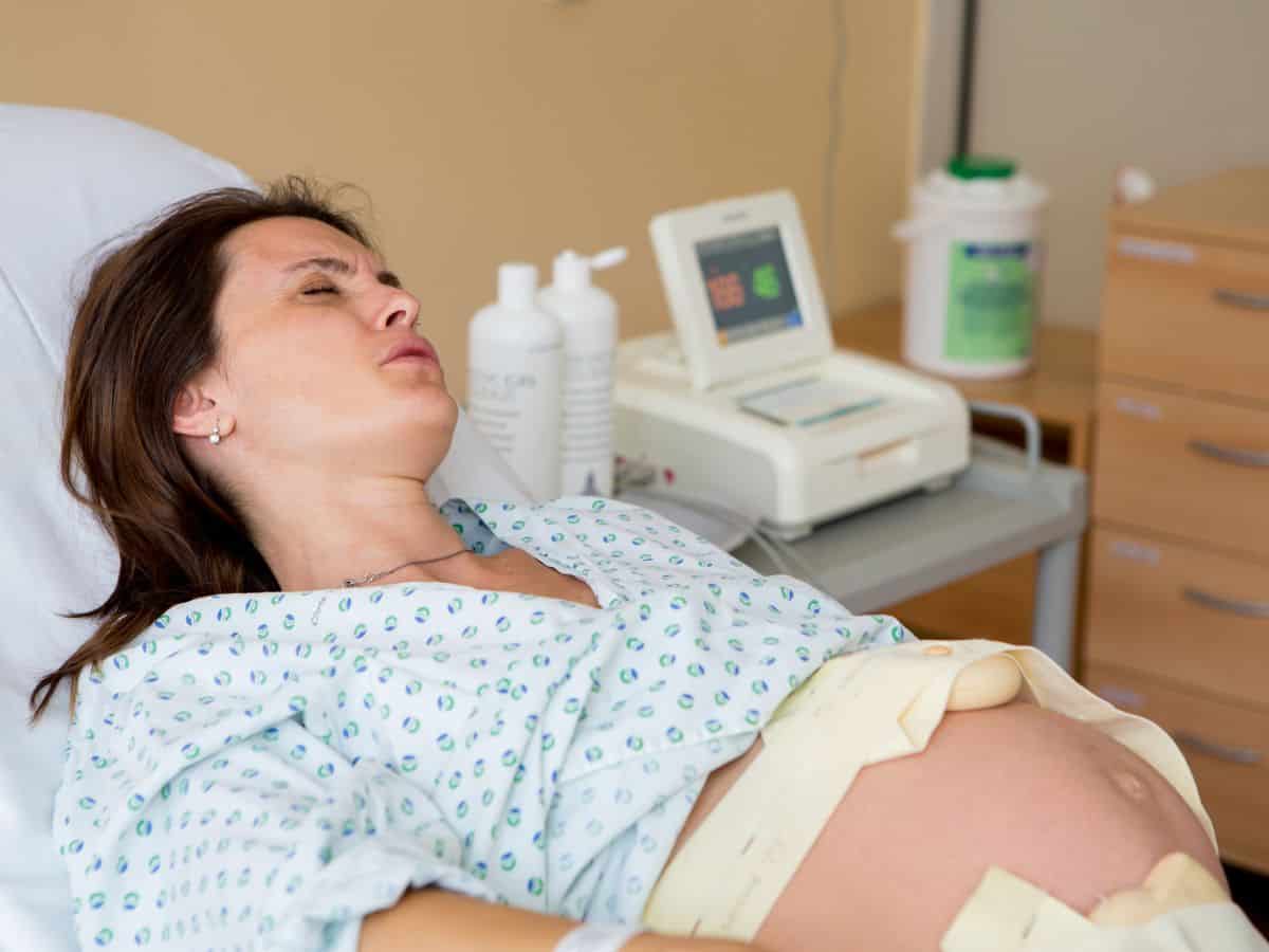 a pregnant woman in a hospital being induced with monitors on her belly