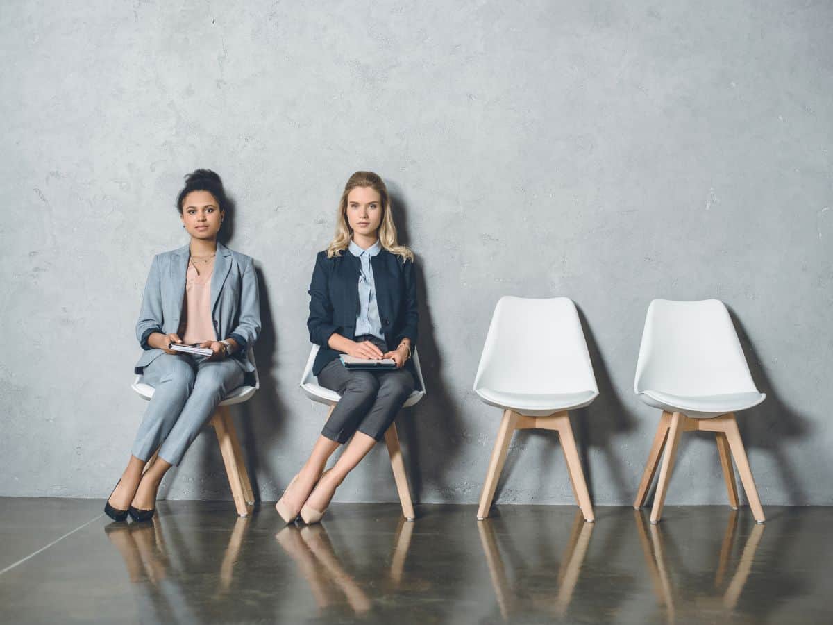 two women sitting in chairs waiting for an interview